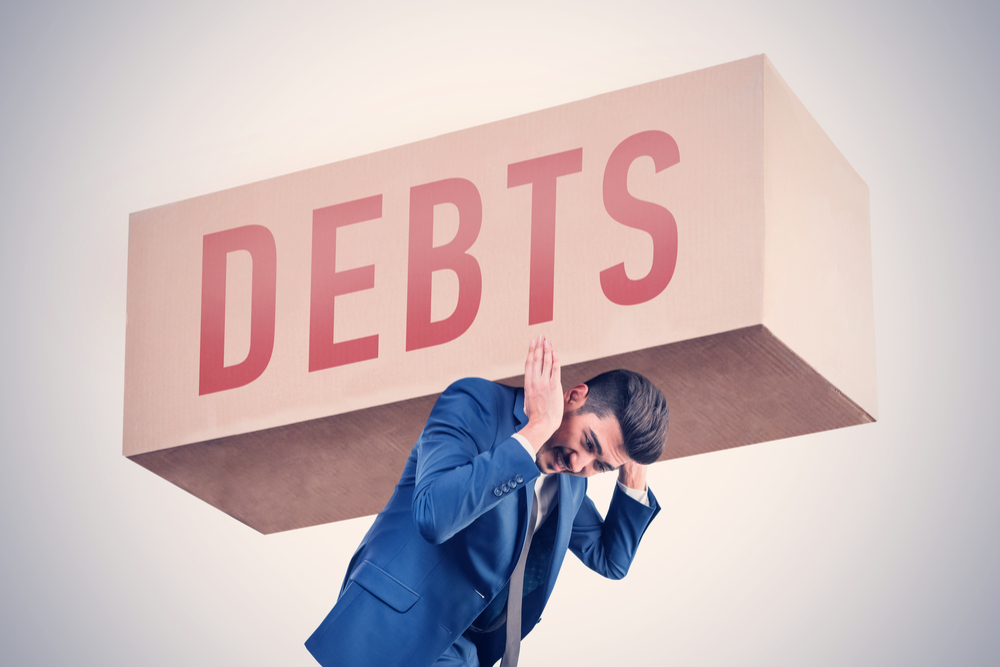 A man holding a Debts sign